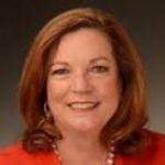 A woman in a red blouse smiling.