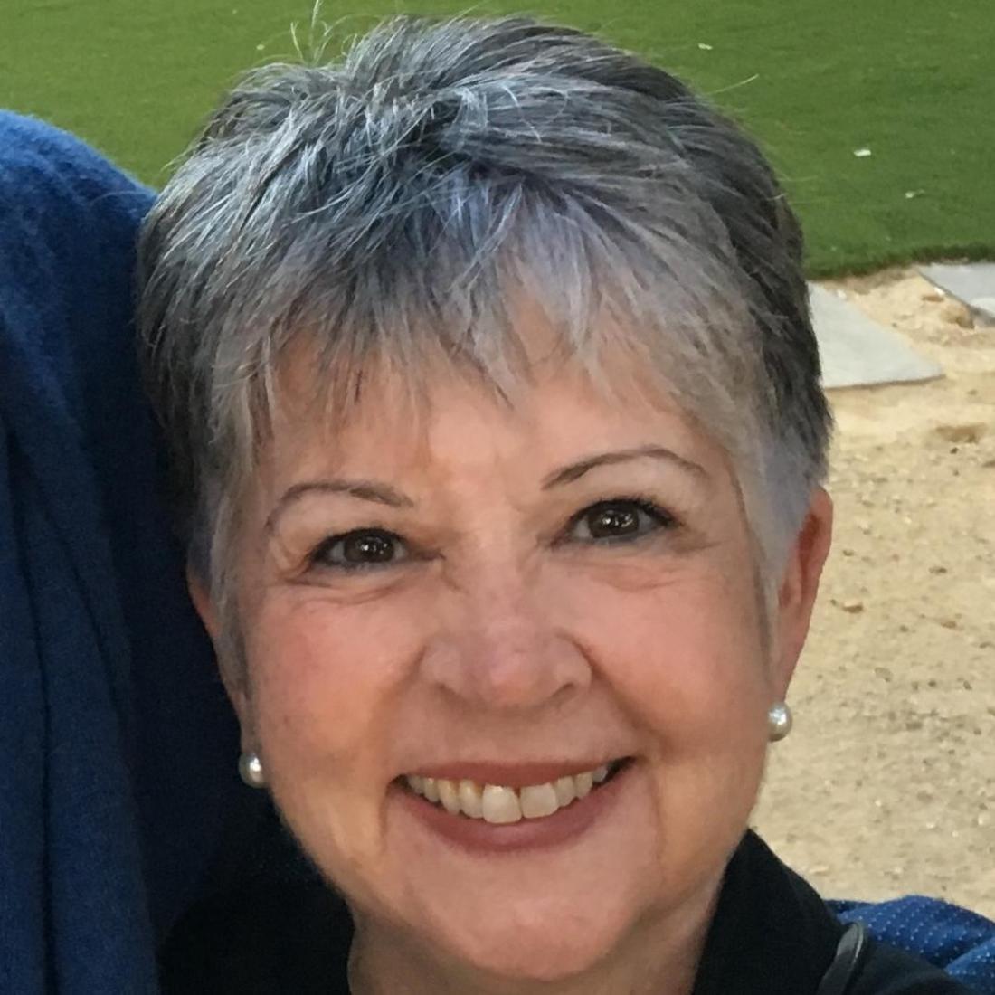 A woman smiling outdoors.