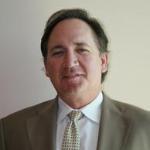 A man in a suit and tie smiling.