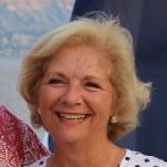 A smiling woman in a white polka dot shirt.