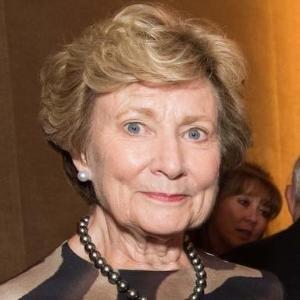 A woman smiling in a formal setting.