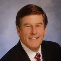 A man in a suit with a light background.