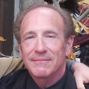 A smiling person in formal attire with an arm around them.