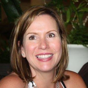 Smiling person with greenery in the background.