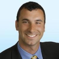 A smiling person in a suit and tie.