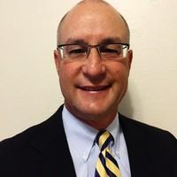 A man in formal attire smiling.