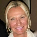 A smiling woman with a white scarf.