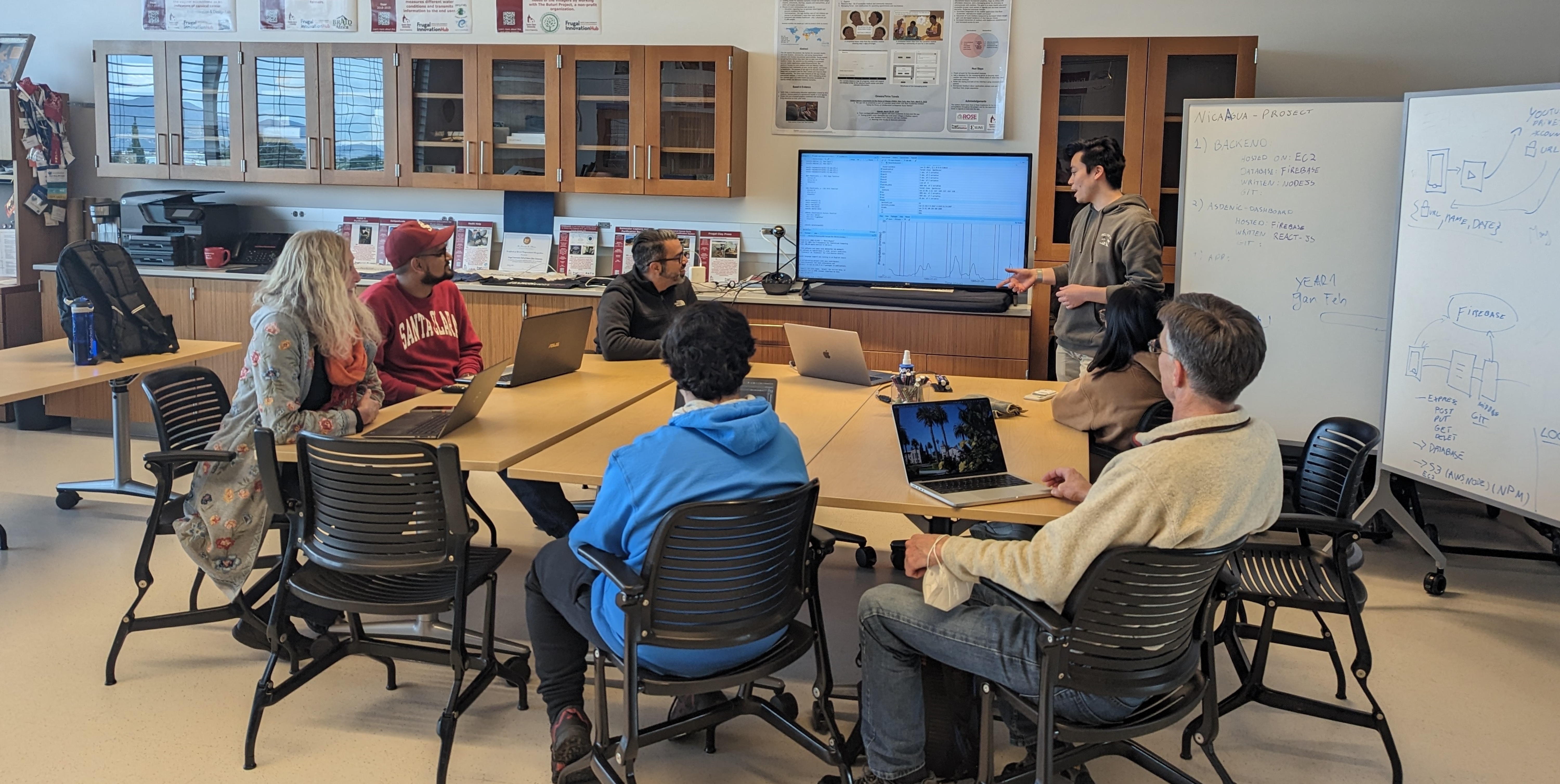 students, faculty, and staff sitting listening to presentation during meeting