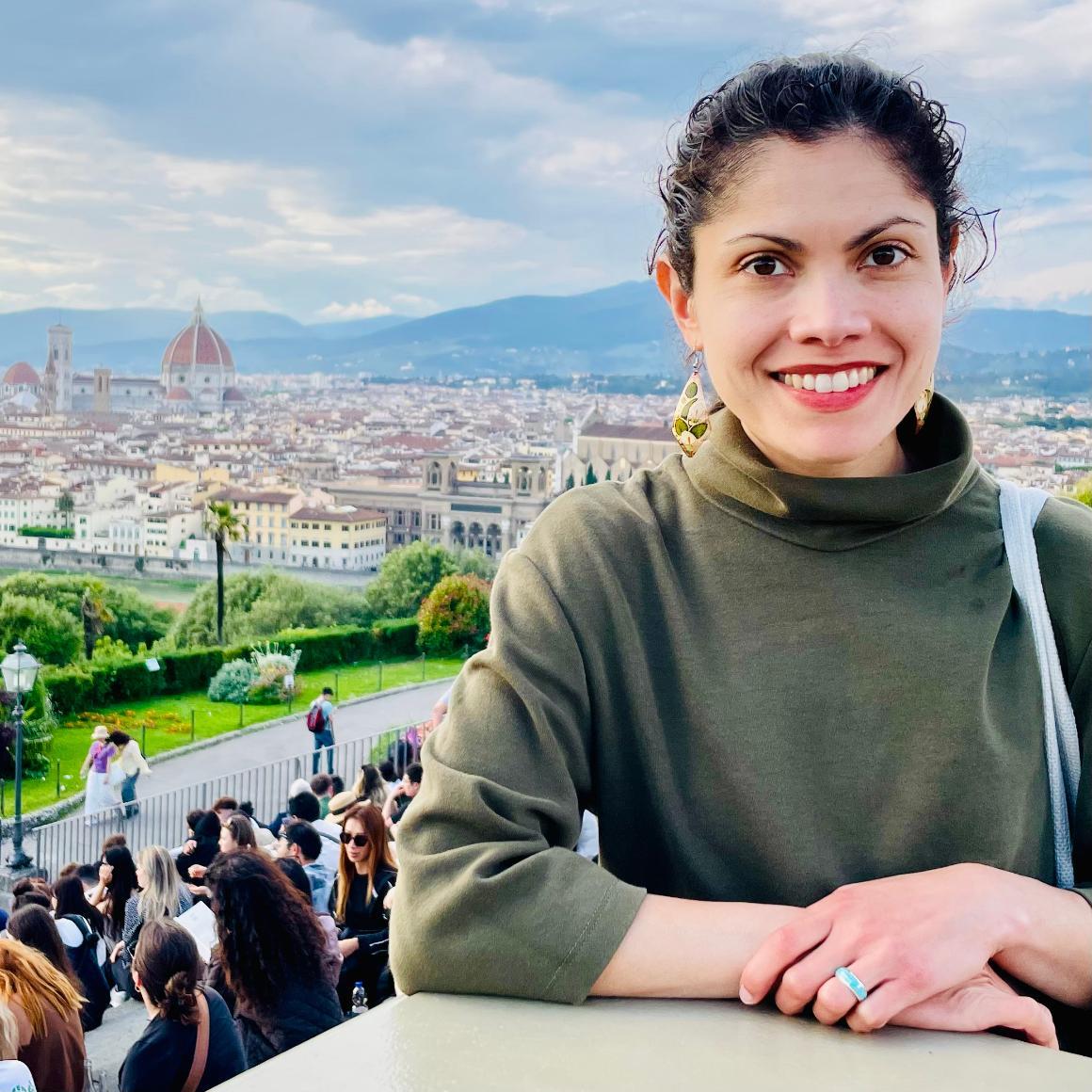 Decorative; Jesica Siham Fernández, PhD: Associate Professor, Ethnic Studies Department in front of a European landscape