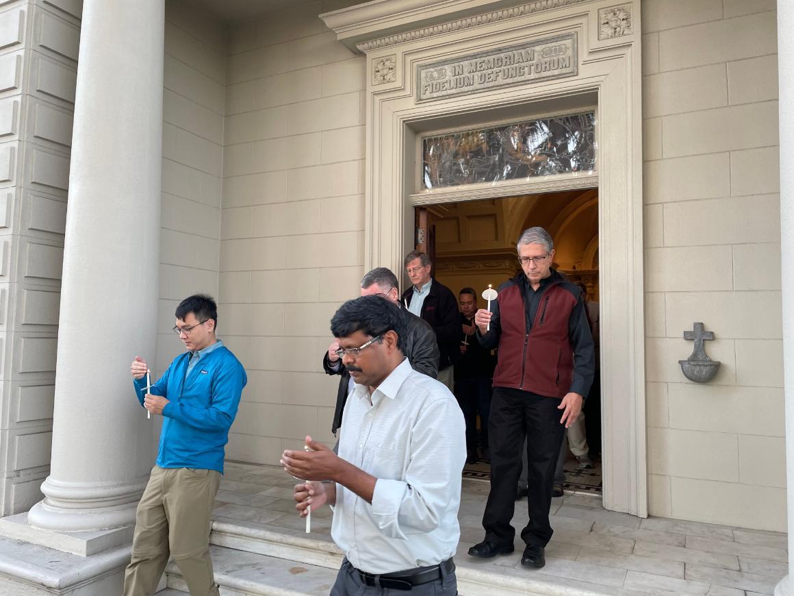 People standing and walking near a building entrance.