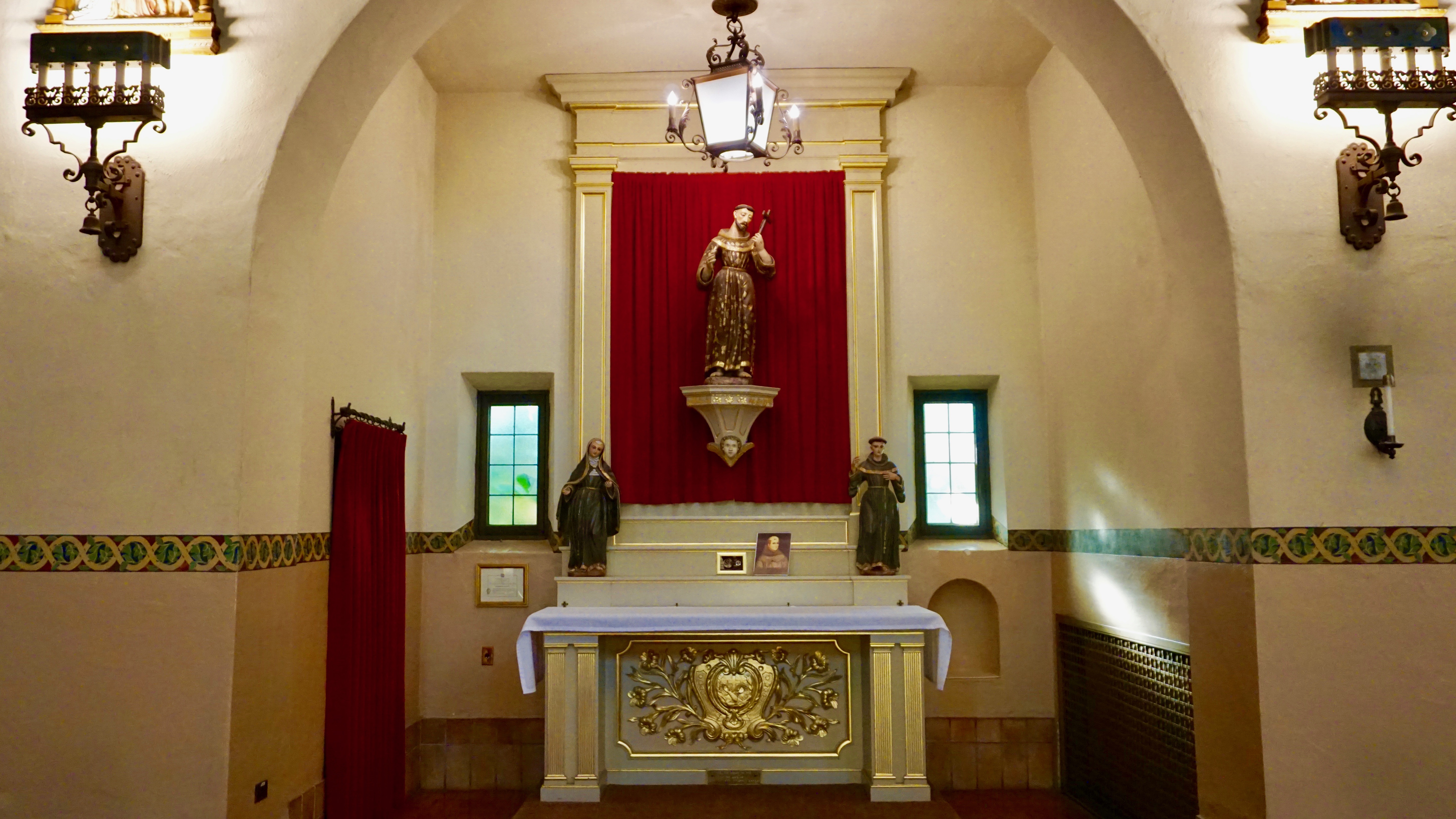 The image shows an ornate side chapel with a central altar and religious iconography.
