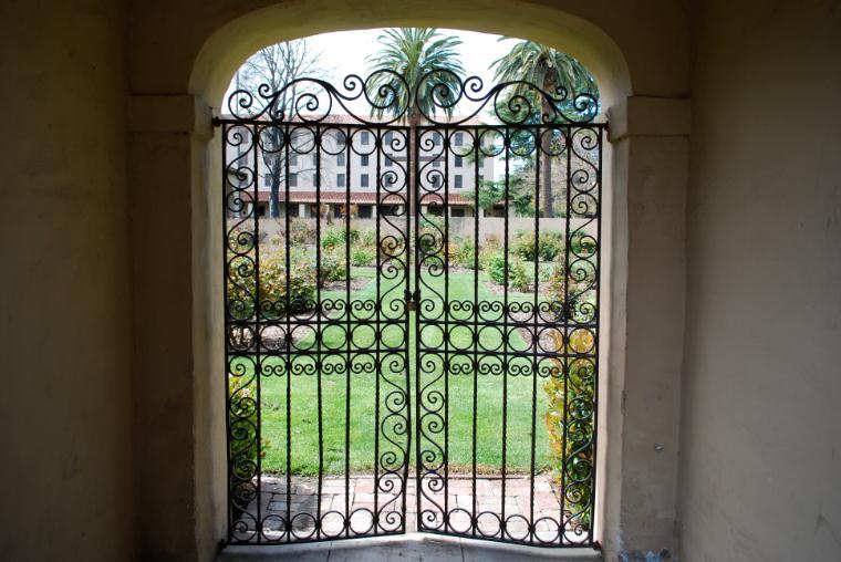 Arched gates leading to a rose garden cemetery.