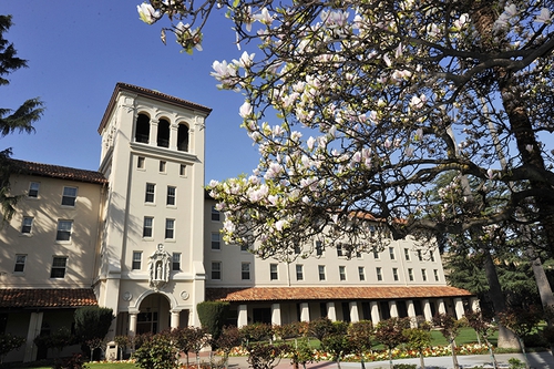 An exterior image of Nobili Hall with flower blossoms.