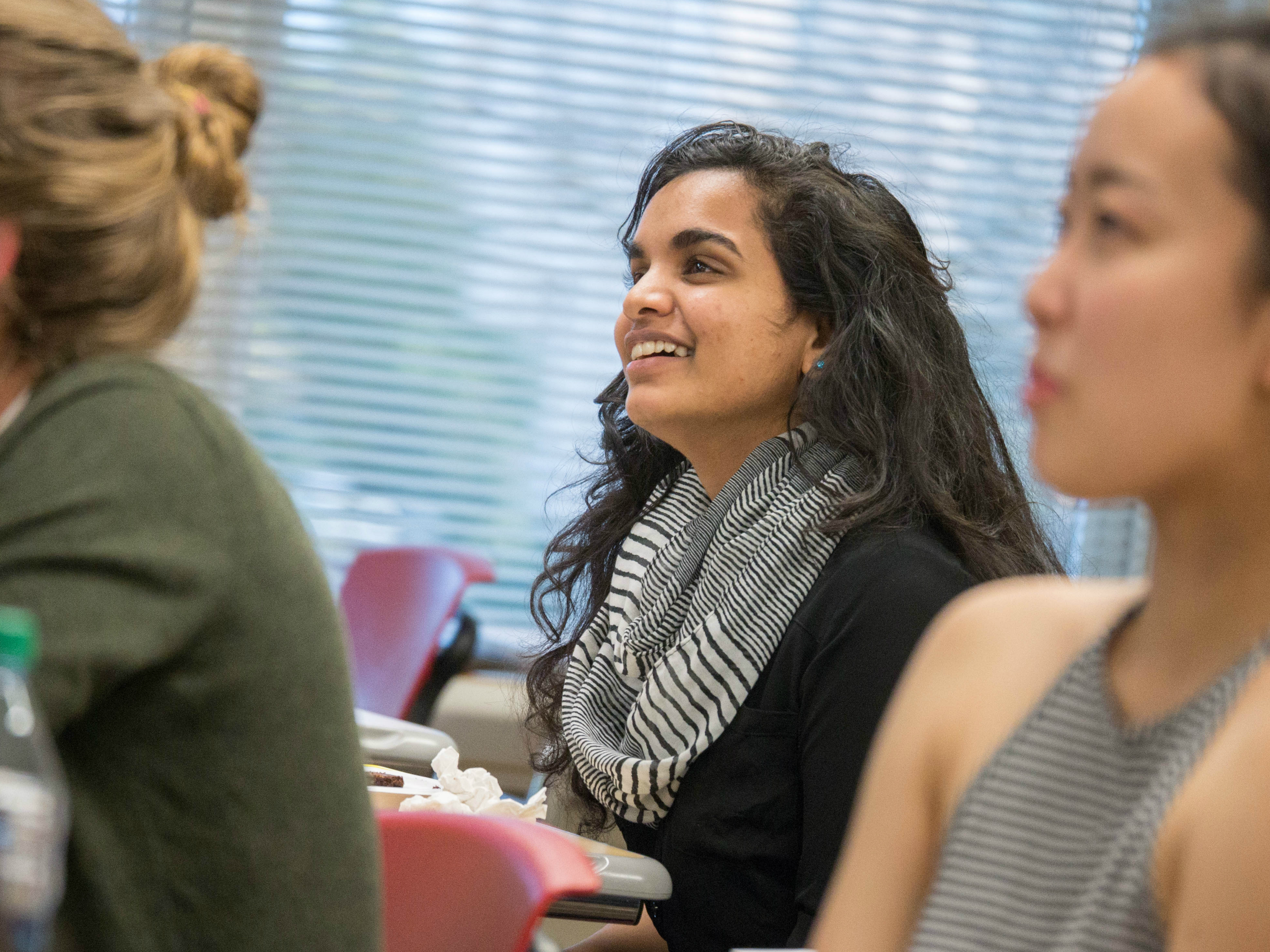 Three people sitting and smiling in a casual setting.