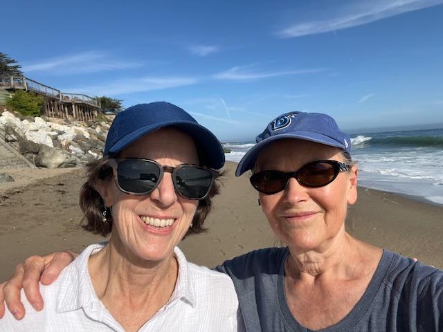 two women in baseball hats at beach