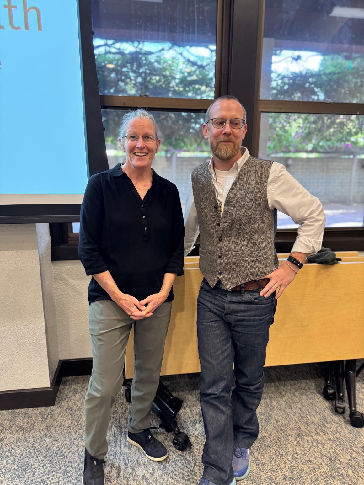 two people stand together smiling