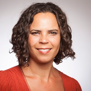 A person smiling in a red top. 