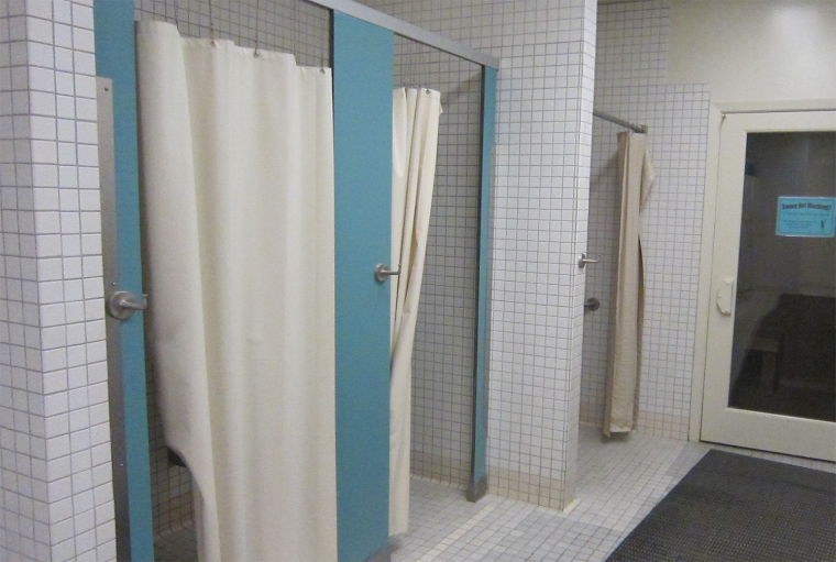 Alt text: Locker room with shower stalls and curtains.