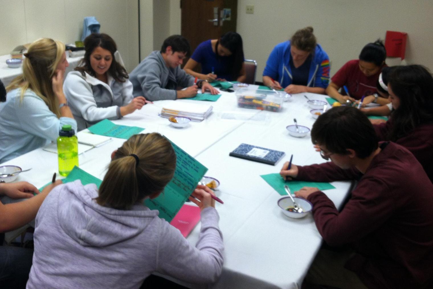 A group of students sitting around a table writing