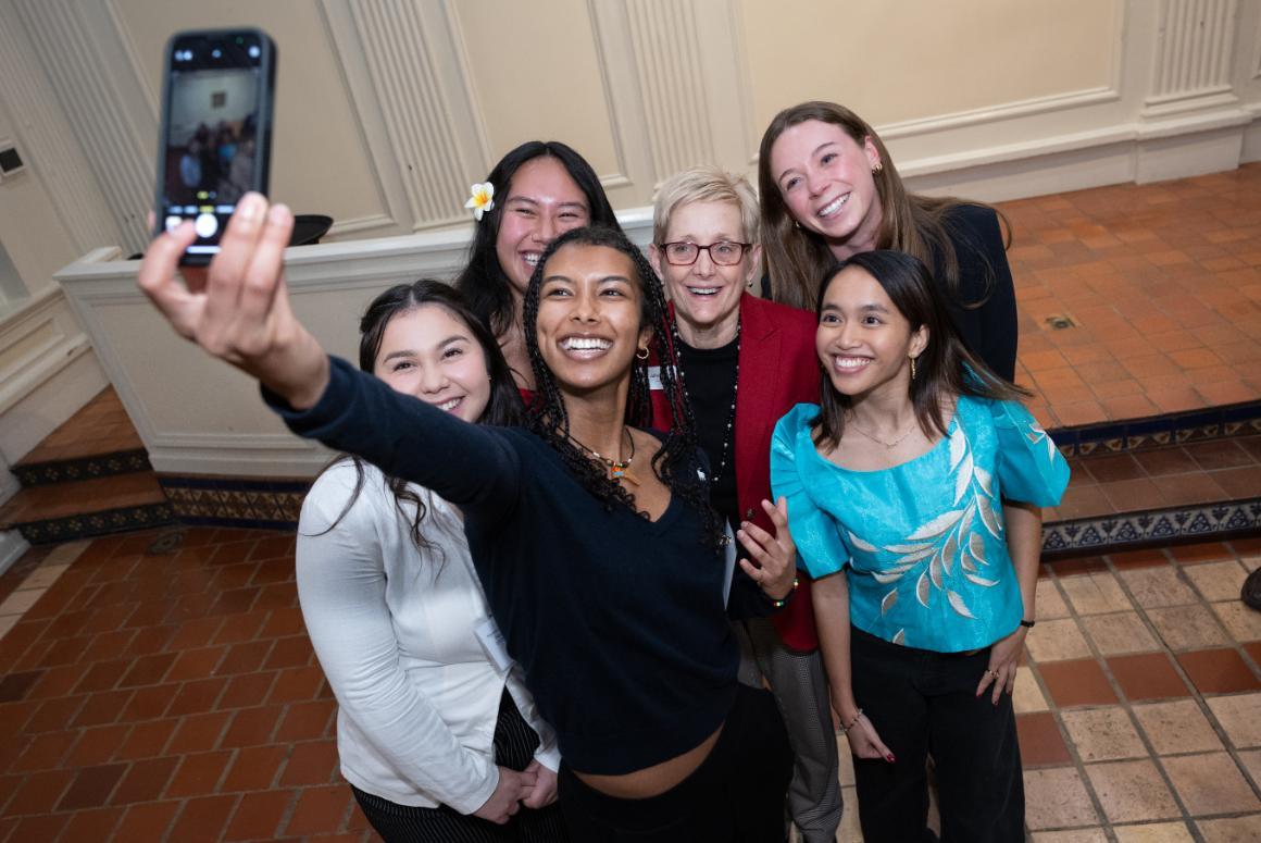A group of smiling SCU students taking a selfie with SCU's President.