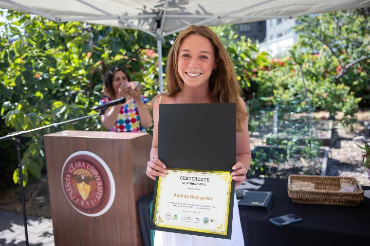 2025 Sustainability Celebration: A student poses with a certificate.