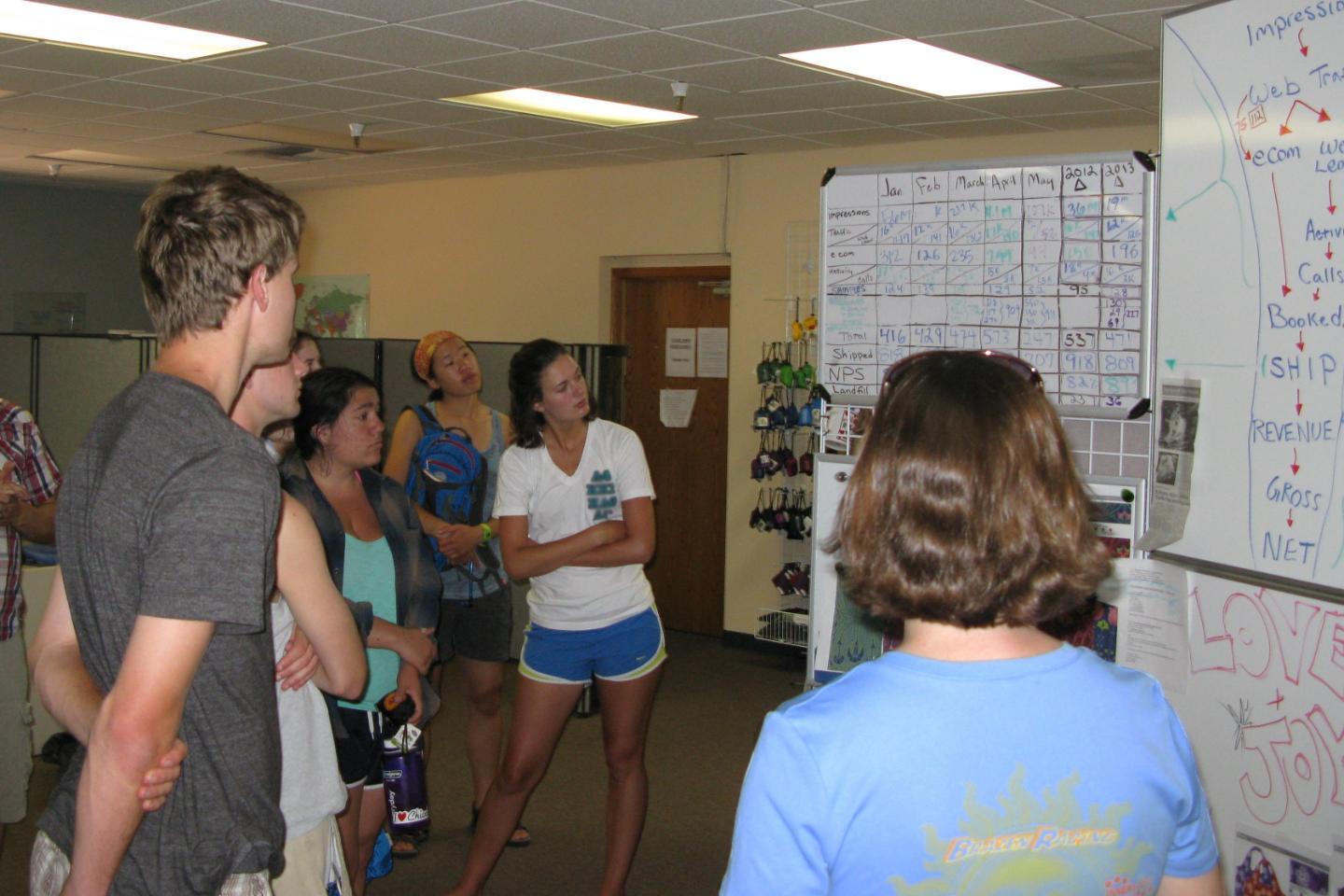 A group of students, faculty, and staff collaborate and look at ideas on a whiteboard