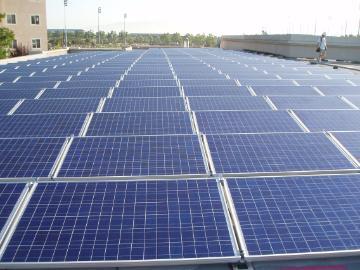 Alt text: Solar panels installed on a rooftop under a clear sky.