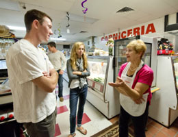 Two people chatting with an employee in a kitchen. image link to story