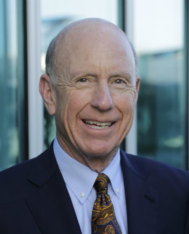 A person smiling while wearing a suit and tie. image link to story