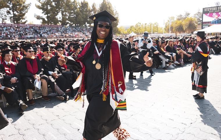 A graduate smiles broadly as she leaves the stage.