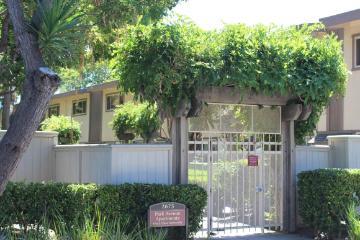 Gated entrance to Park Avenue Apartments surrounded by greenery and trees.