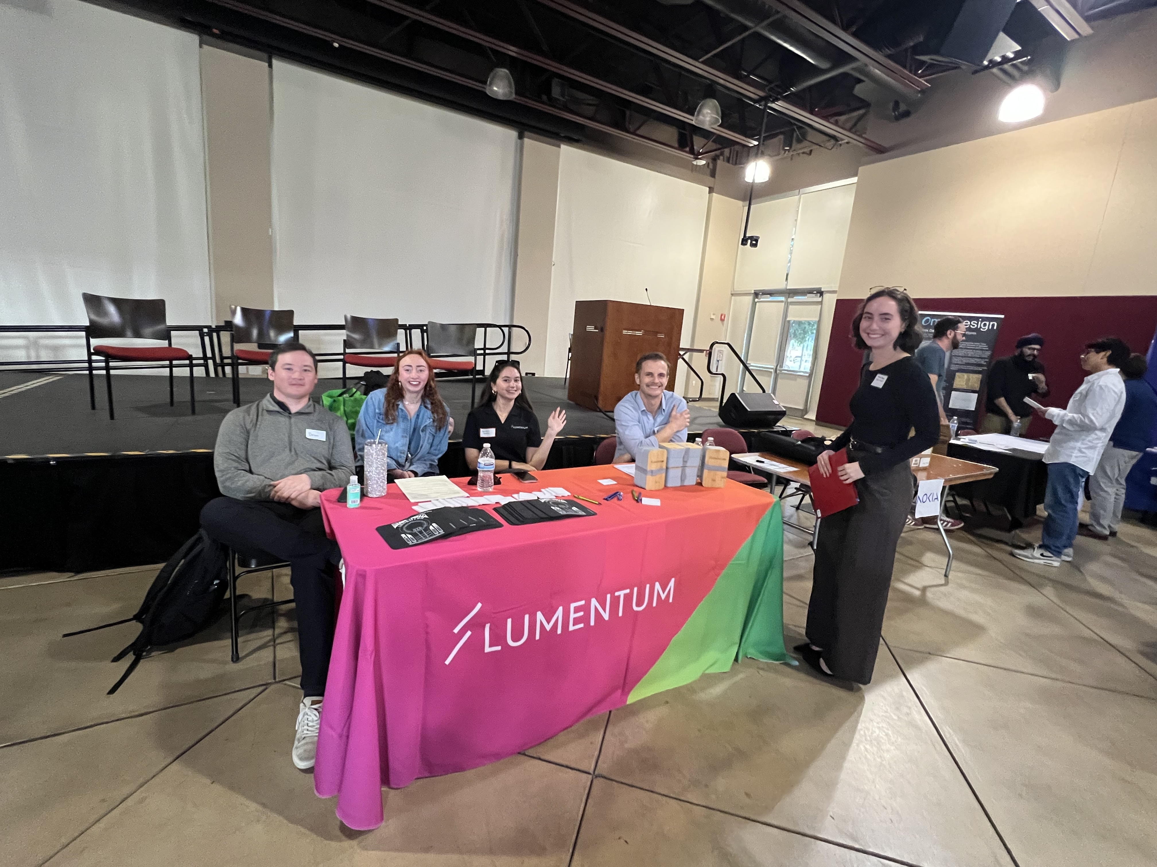 A student smiles with representatives from Lumentum.