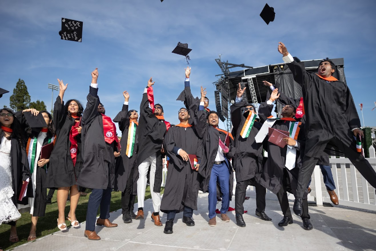 Engineering students throwing their graduation caps