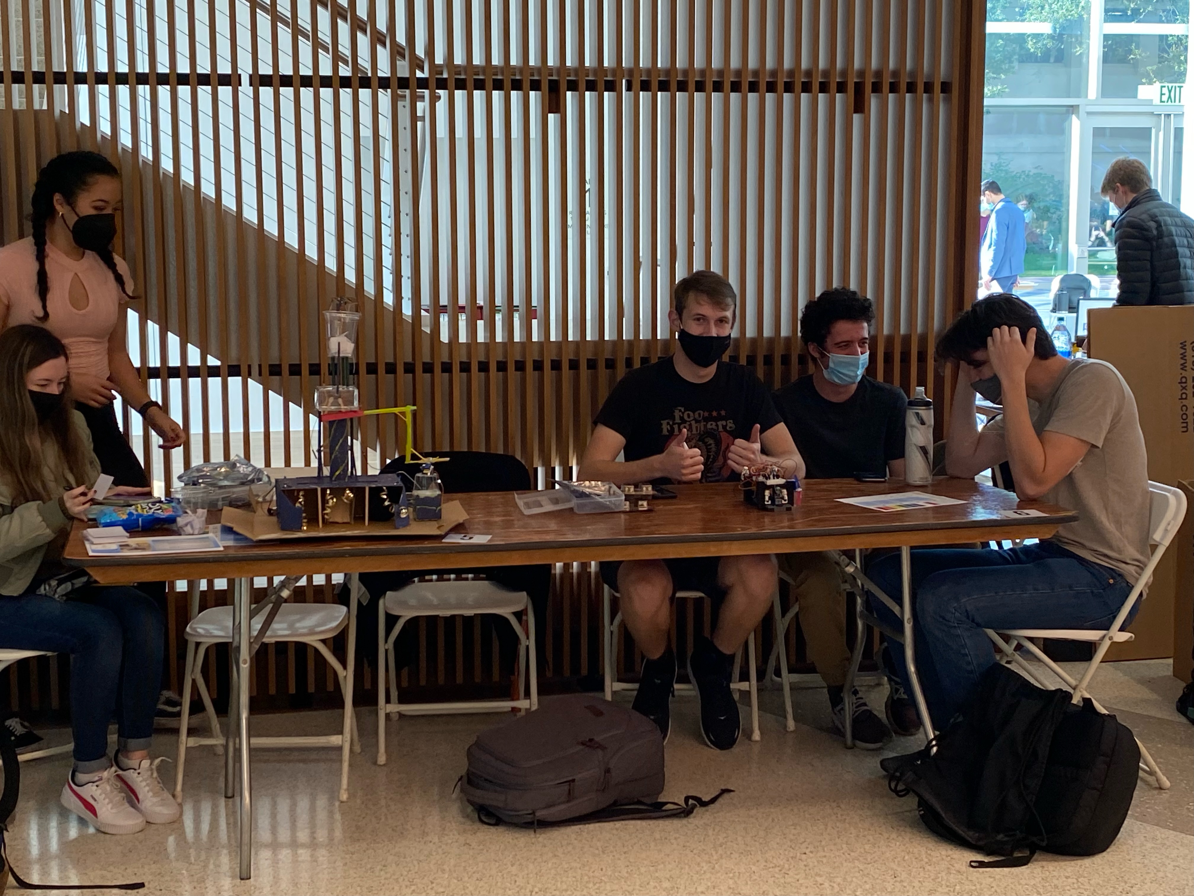 People working with robots and laptops in a modern room.