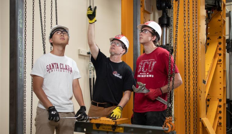 Lab manager and students using the frame equipment in the Civil Engineering Lab.