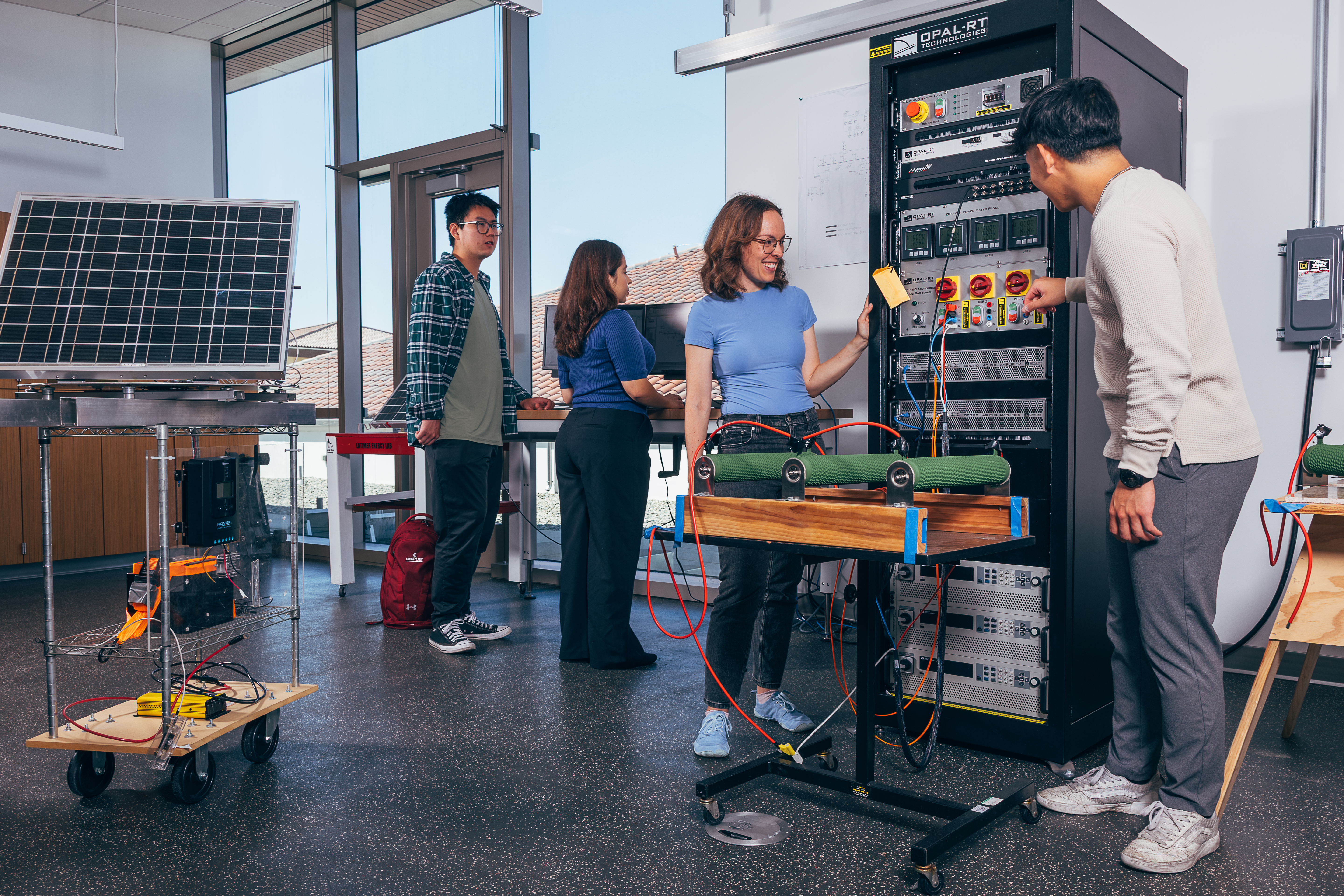 4 students in a lab working with solar panels