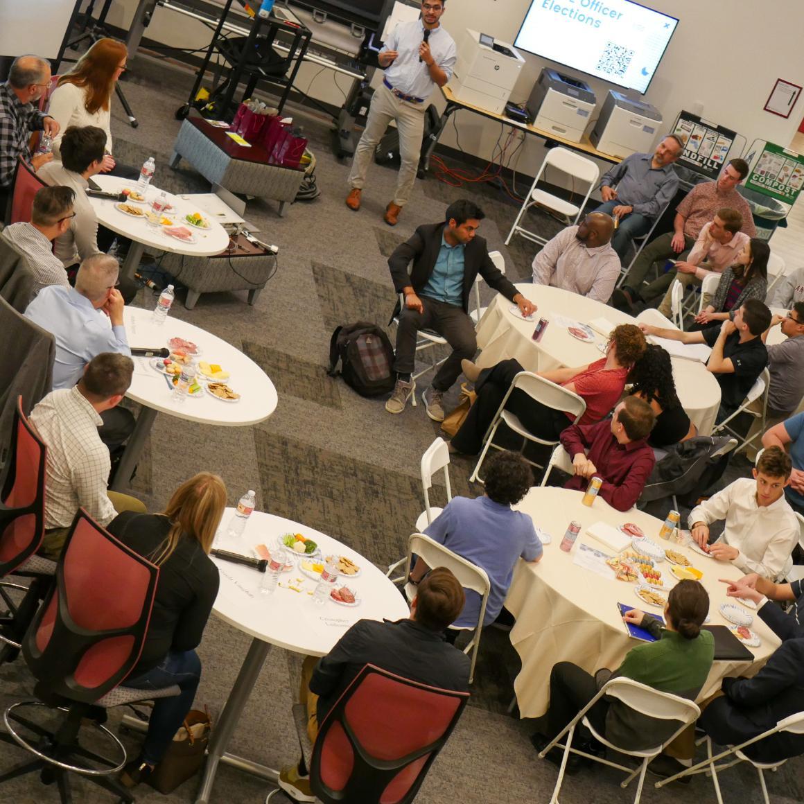 Mechanical engineering alumni and current students seated at tables during networking event