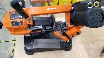 Alt text: A band saw machine cutting a steel plate.