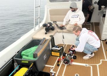 Students working on vertical profiler during marine deployment