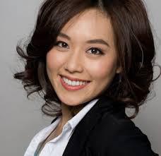 A woman smiling wearing a white shirt and black blazer. image link to story