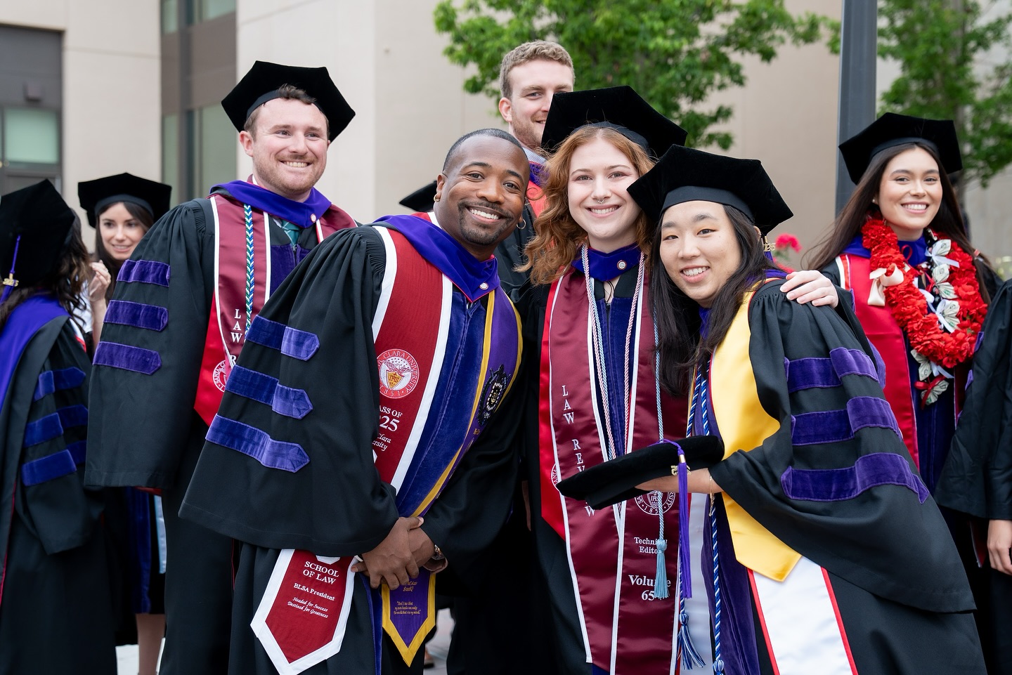 group of students in law graduation regalia and celebration sashes