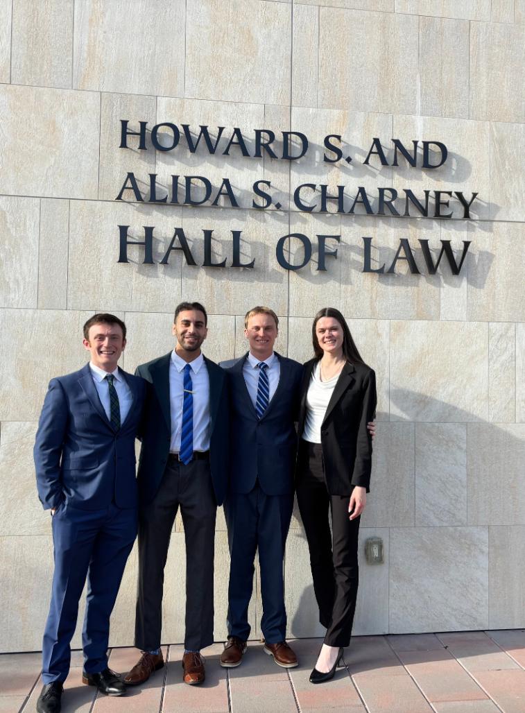 Four Finalists standing in-front of the Law School Building in business attire