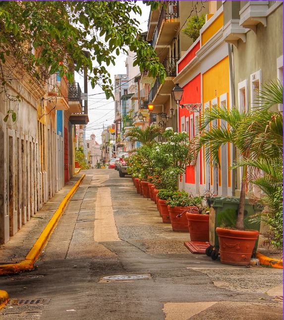street in Puerto Rico with potted plans and colorful buildings 