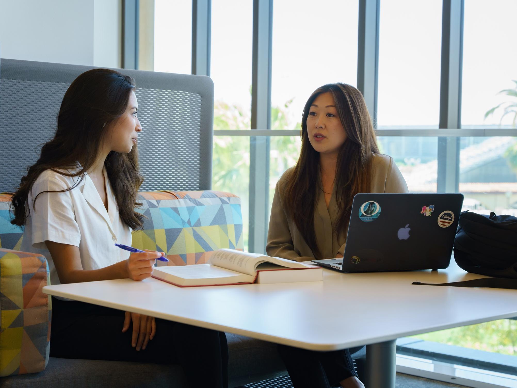 Two women talking at table 