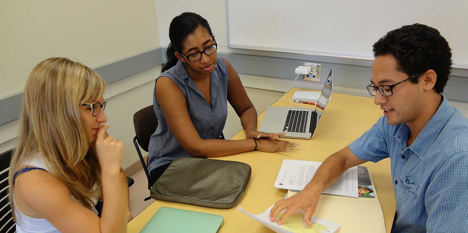 3 people speaking at a computer desk