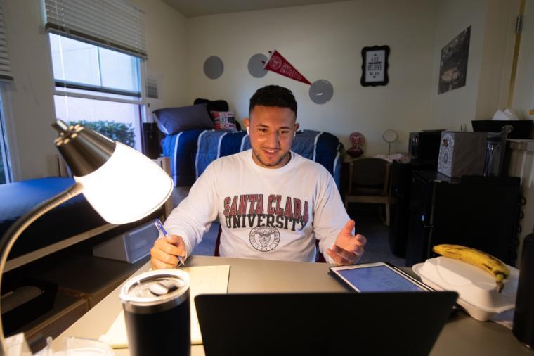 A student working on his laptop at home.