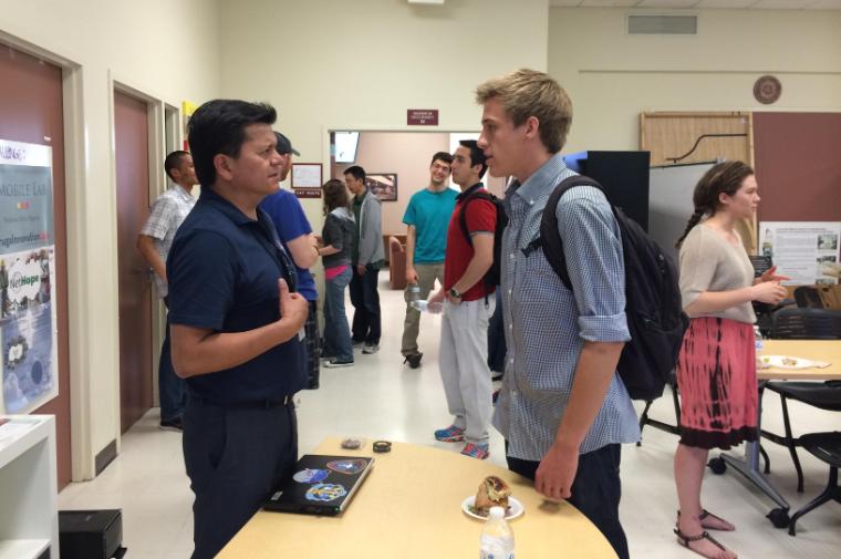 A student talks with a NASA engineer during Lunch with an Entrepreneur